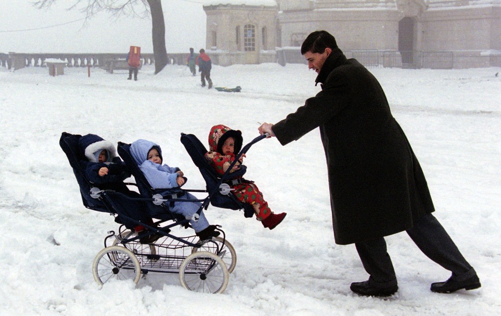 Un homme pousse ses trois enfants à travers la neige dans la ville de Lyon, au sud-est de la France